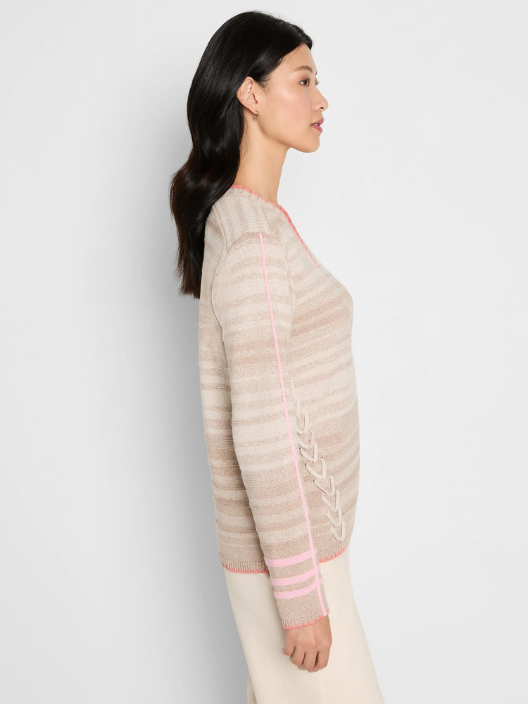 Beige multi-tone striped sweater with pink trim at neckline, cuffs, and down the side seams with braided detail.