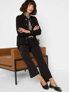 Black textured knit jacket with military buttons, shoulder epaulets, and fringe trim on edges.