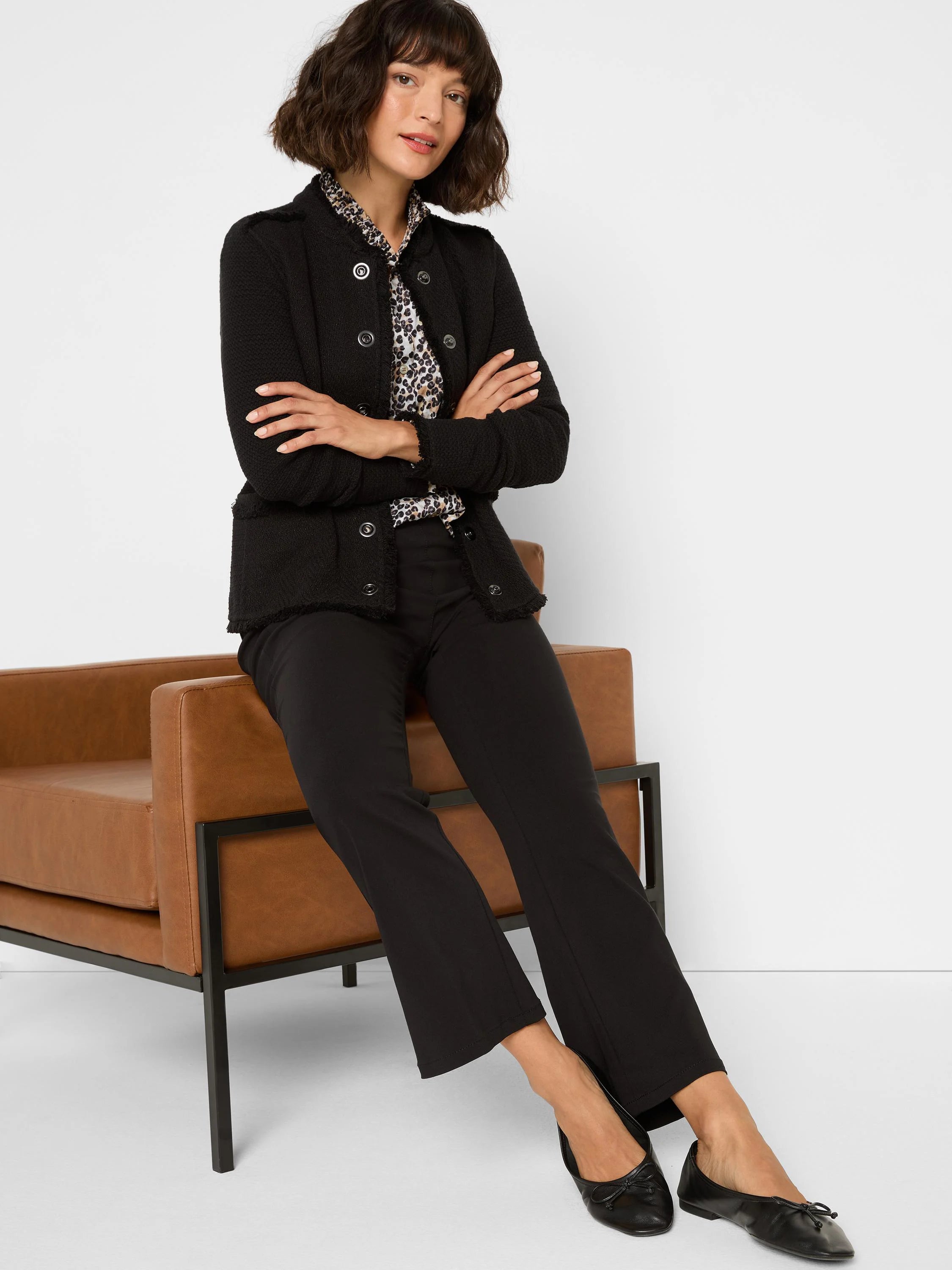 Black textured knit jacket with military buttons, shoulder epaulets, and fringe trim on edges.