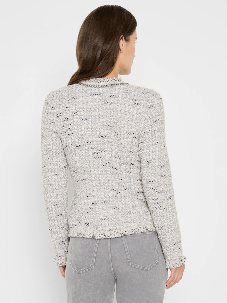 Light grey mix knit jacket with silver chain trim neckline, fringe at hem & cuffs. Model from back.