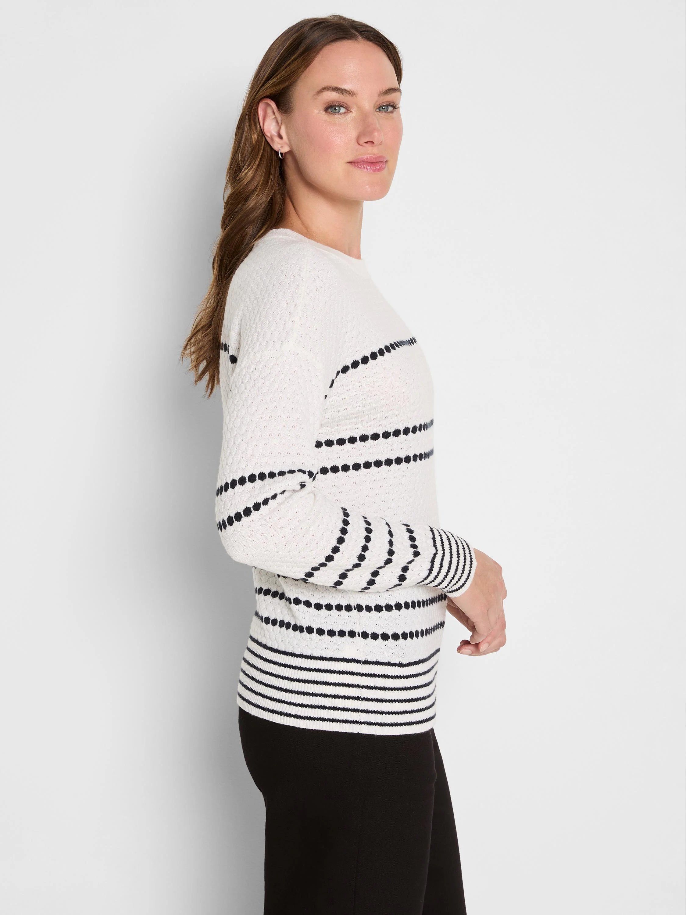 Textured cream knit sweater with black horizontal dot patterns. Striped cuffs and hem.