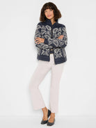 Beige and navy horizontal stripe knit sweater, partially seen under an open jacket.
