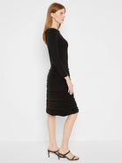 Black long-sleeve dress. Ribbed top, twirl skirt with horizontal fuzzy trim.