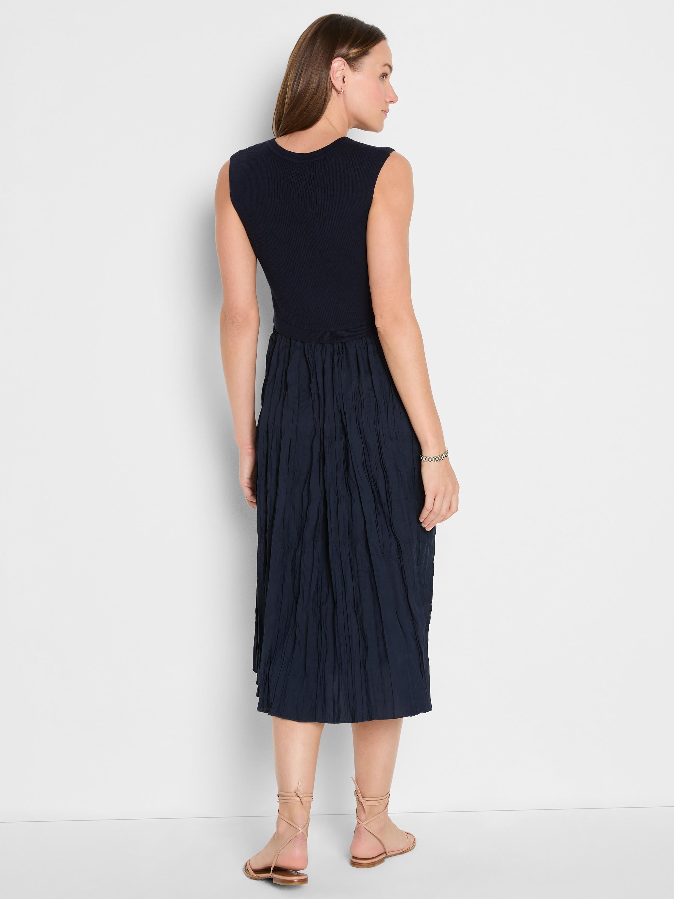 Navy sleeveless midi dress with a fitted ribbed knit bodice and a high-waisted, textured crinkle skirt.