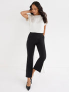 Black high-waisted pull-on trousers have a slim fit and a cropped ankle length with a subtle kick-flare detail.