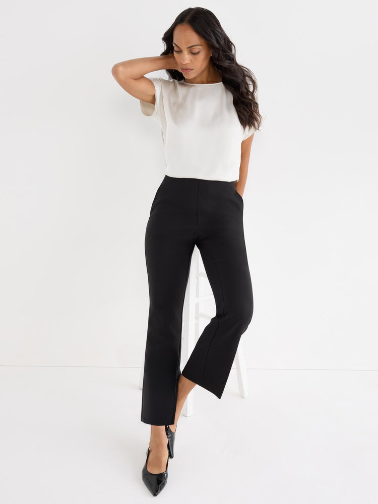 Black high-waisted pull-on trousers have a slim fit and a cropped ankle length with a subtle kick-flare detail.