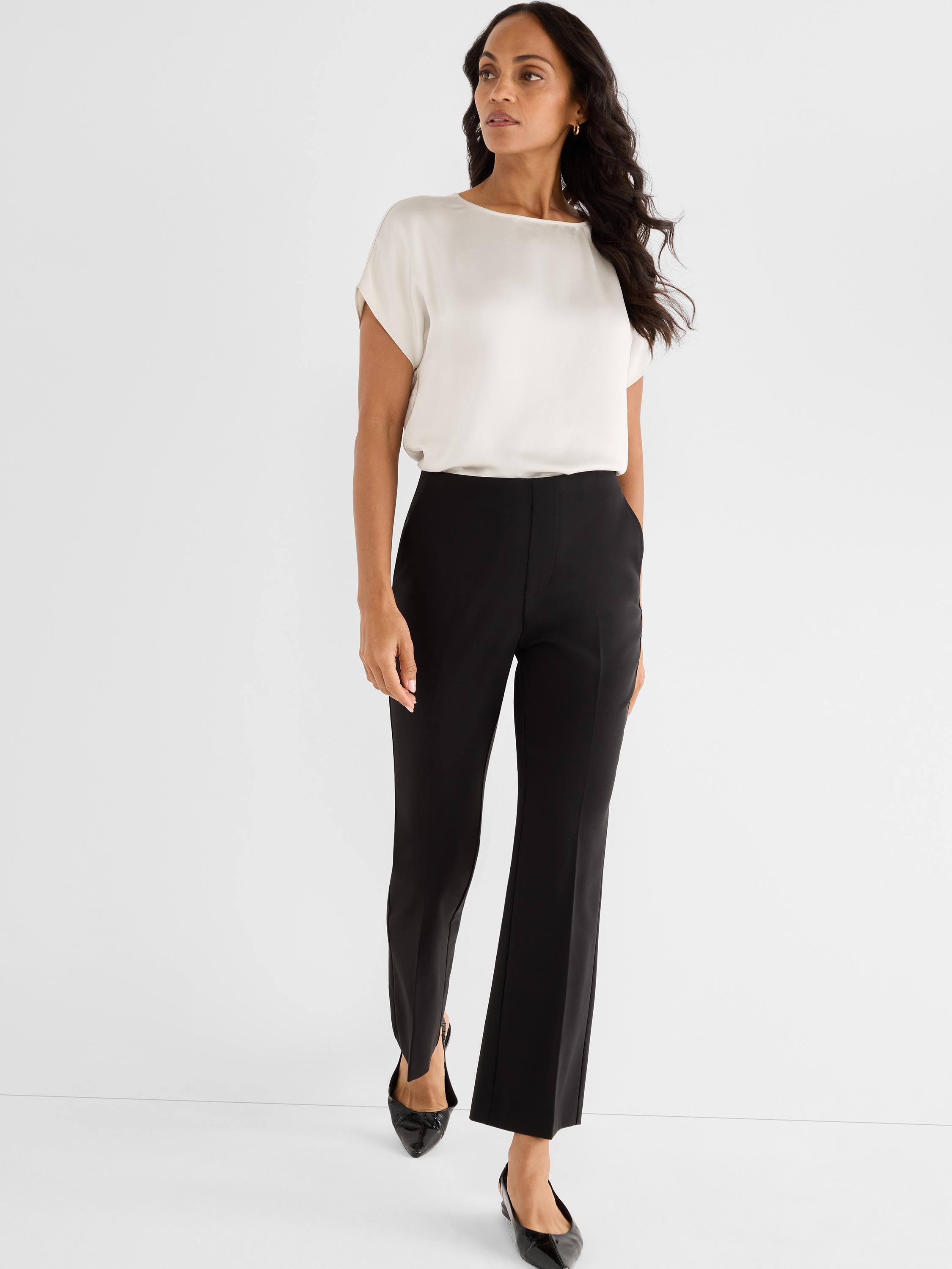 Relaxed white cap-sleeve top and high-waisted black tailored pants with a slight flare and side ankle split.