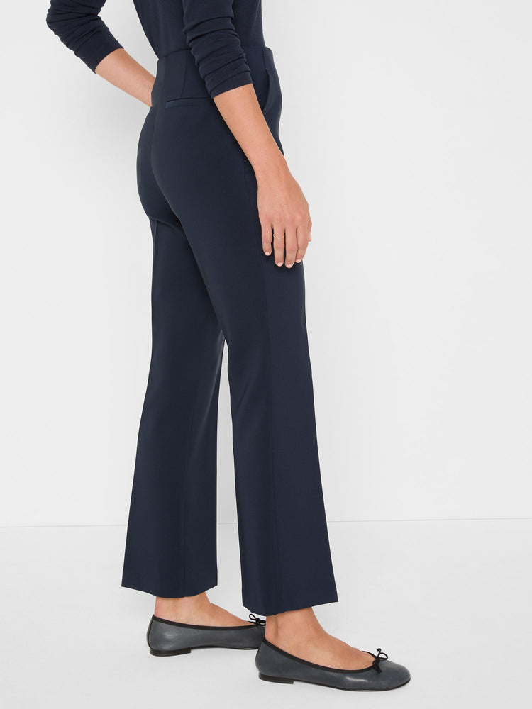 Model wears navy high-waisted cropped trousers with a sleek, subtly flared leg.