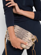 Dark navy ribbed knit separates are shown accessorized by a contrasting light beige studded snakeskin clutch bag.