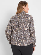 Cream, tan & black leopard print top with a ruffled high collar and gathered long sleeves, seen from behind.