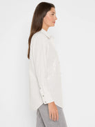 Off-white button-up shirt with thin grey pinstripes and subtle iridescent sequins.