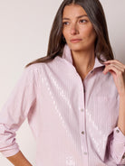 Light pink collared shirt with thin gray stripes, scattered silver sequins, and a button-down front.