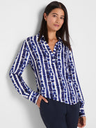White top with blue shibori vertical stripes; patterns feature irregular, ink-blot shapes. V-neck & collar.