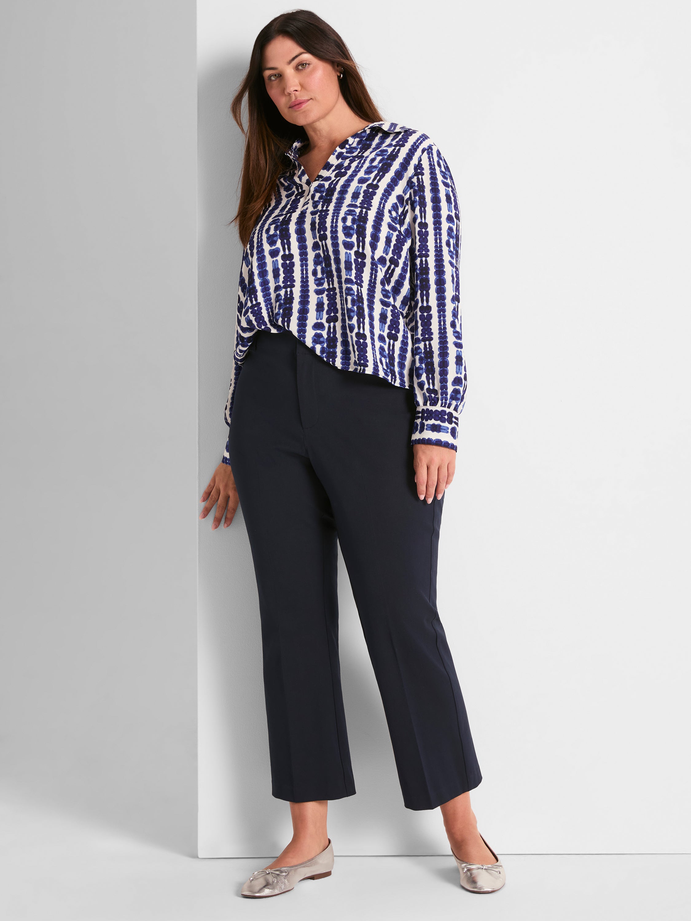 Flowy blue shibori print shirt and dark navy high-waisted straight-leg cropped pants create a chic, professional outfit.