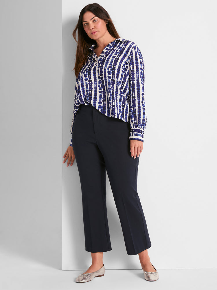 Flowy blue shibori print shirt and dark navy high-waisted straight-leg cropped pants create a chic, professional outfit.