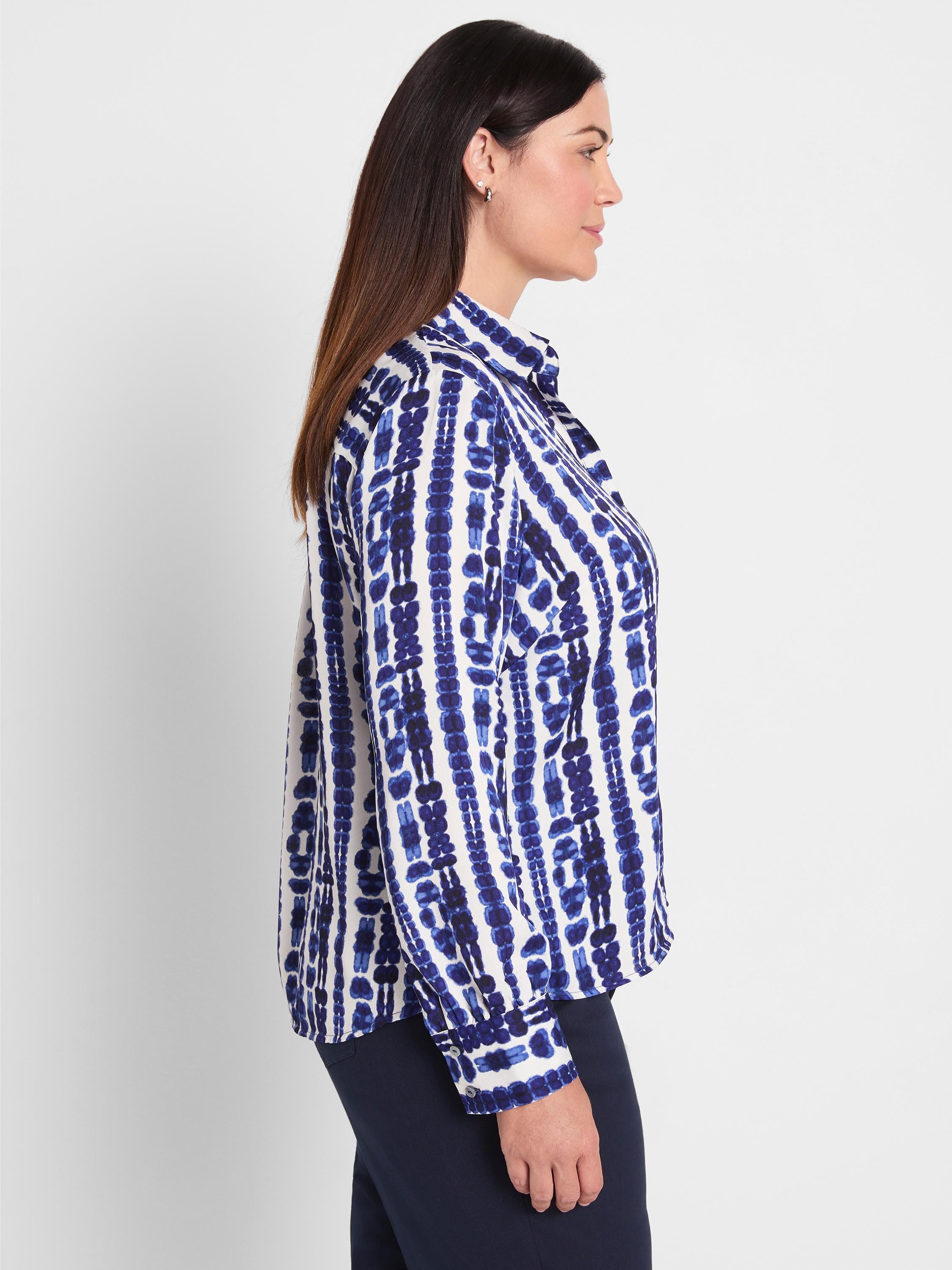Blue and white collared shirt in a relaxed fit featuring an abstract vertical stripe pattern and long sleeves.