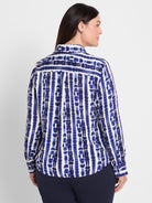 A white long-sleeve button-down shirt with a bold vertical blue tie-dye pattern is worn in a classic fit.
