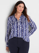 A relaxed blue and white abstract shibori print long-sleeve popover blouse with a collared V-neckline.