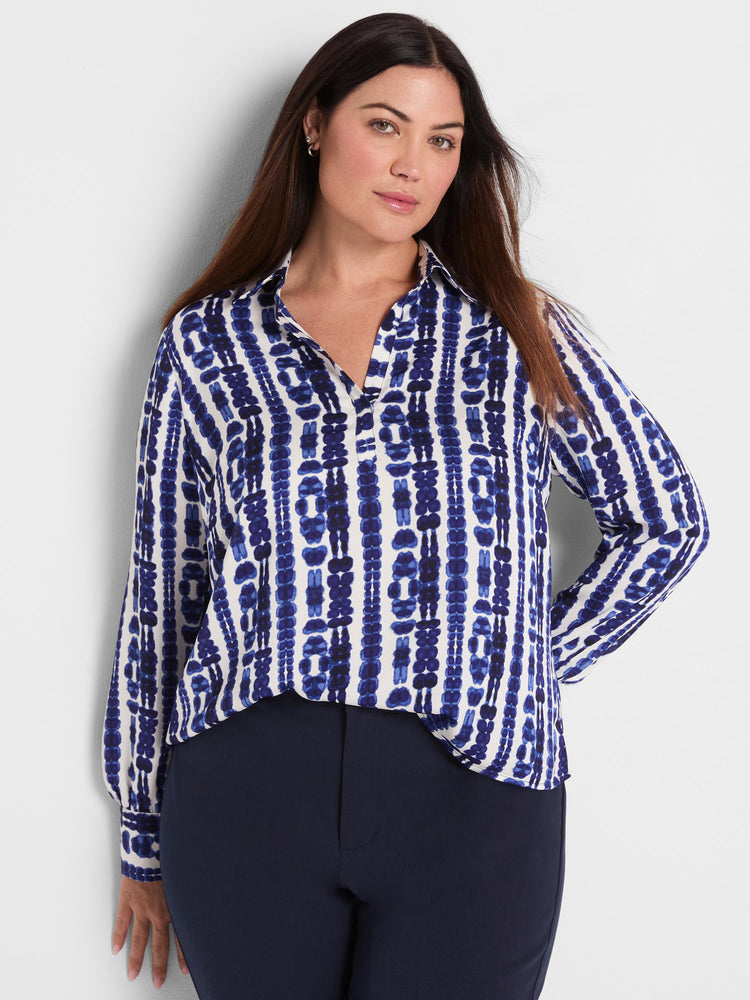 A relaxed blue and white abstract shibori print long-sleeve popover blouse with a collared V-neckline.