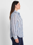 Light blue cotton shirt with vertical stripes in various blues, brown, and tan. Features a collar, button-front, and long...