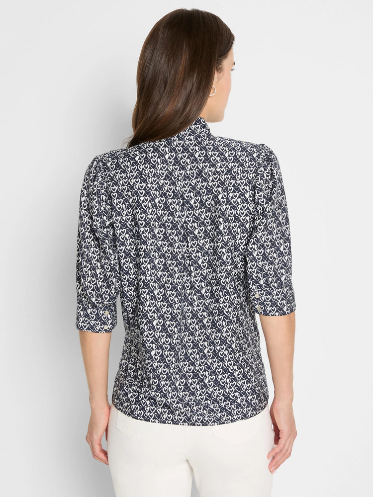Back view of a dark blue shirt with a white etched heart pattern, high collar, and three-quarter sleeves.