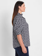 Navy shirt with white etched heart pattern, ruffled stand collar, and 3/4 sleeves.