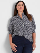 Dark blue collared button-down shirt with small white etched heart pattern and puffed short sleeves.