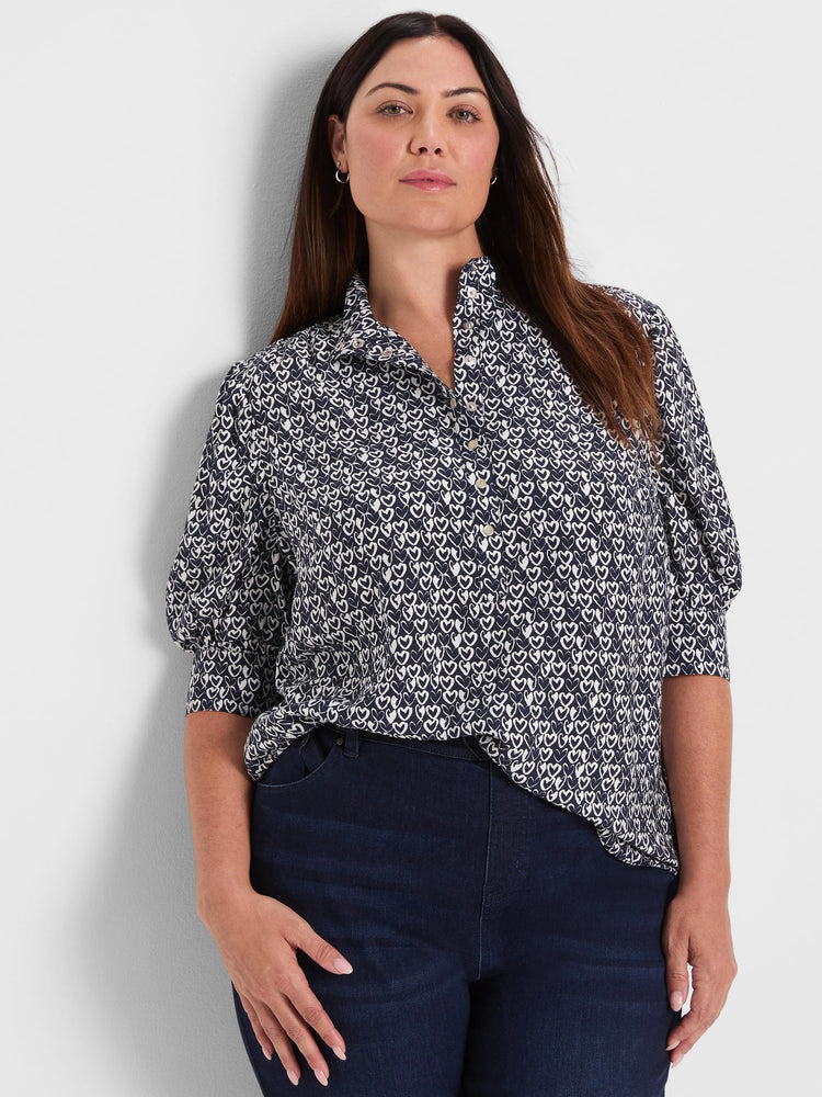 Dark blue collared button-down shirt with small white etched heart pattern and puffed short sleeves.