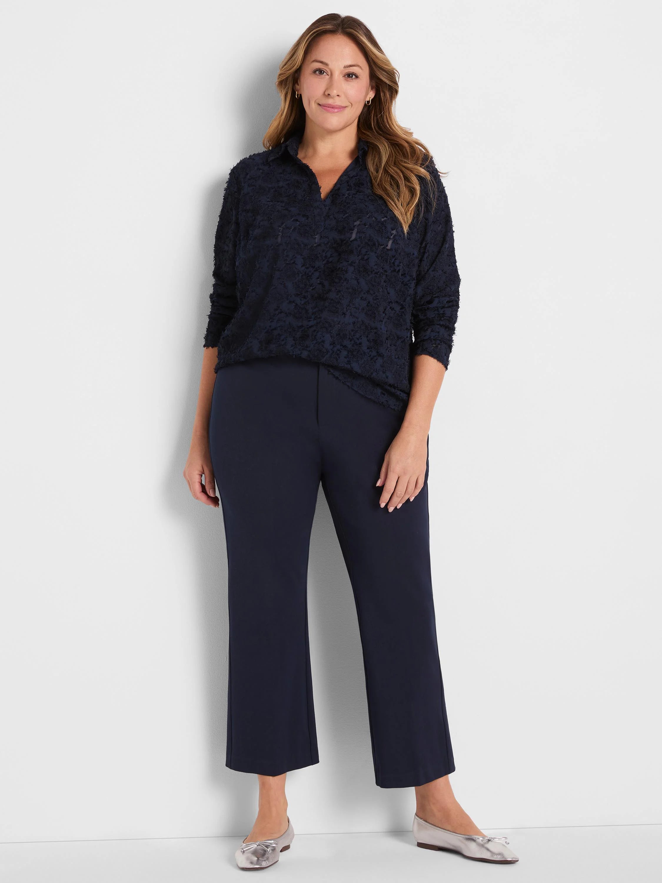 Dark navy blue clipped jacquard top with a textured finish, V-neck, collar, and long sleeves.