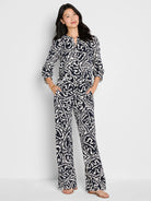 Indigo blue top with white abstract leaf pattern, notched V-neck, 3/4 sleeves.