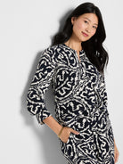 Off-white abstract pattern on dark indigo long-sleeved crepe top. Features a notch V-neck.