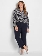 Indigo double crepe top with an abstract off-white wavy leaf pattern. Features long sleeves and a notch neckline.