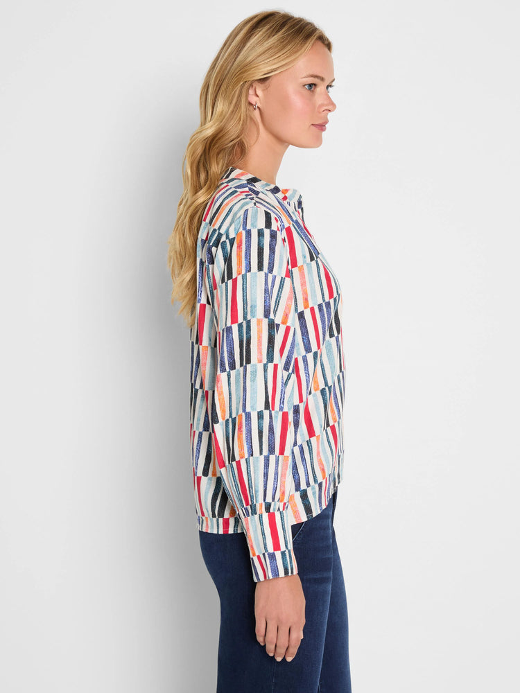 Cotton top with colorful, staggered vertical stripes: red, blue, orange, and black on cream.