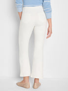 Off-white bootcut jeans, rear view, showing two back patch pockets and a subtle flare at the hem.