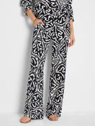 Wide-leg pants with an indigo and off-white abstract leaf pattern, featuring pockets.