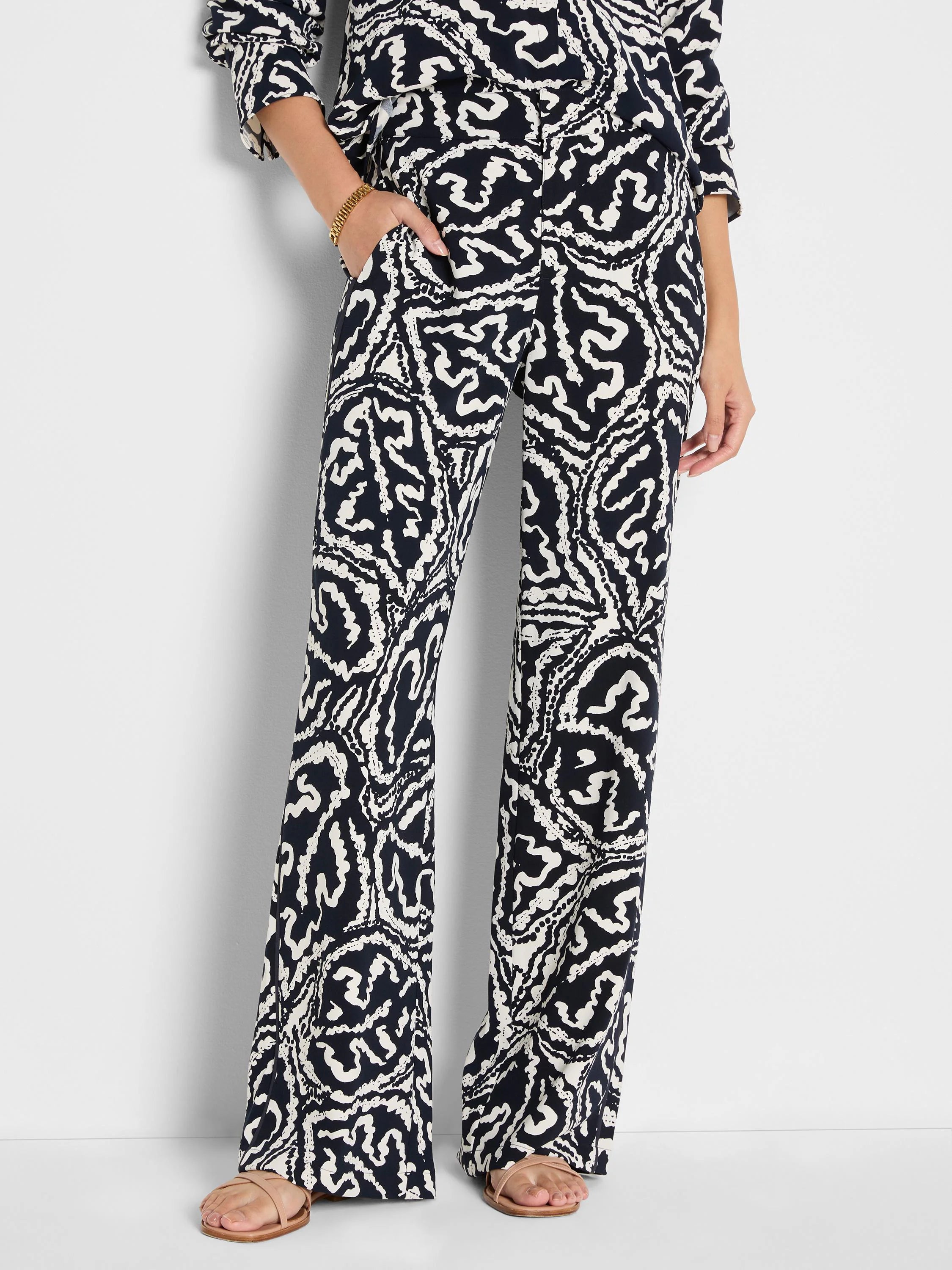 Wide-leg pants with an indigo and off-white abstract leaf pattern, featuring pockets.