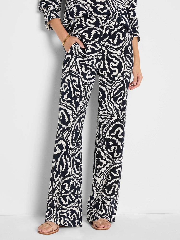 Wide-leg pants with an indigo and off-white abstract leaf pattern, featuring pockets.