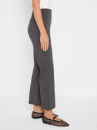 Dark grey high-waisted bootcut pants, smooth fabric with a subtle leg flare.