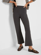 Dark grey bootcut pants on a model. Features a high waist, smooth fabric, and a slight flare at the hem.