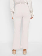 Pale beige bootcut pants, shown from the back. Features a high waist and two back patch pockets.