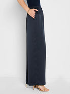 Dark navy, glossy wide-leg pull-on pants. Features an elastic waist and side pockets.
