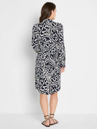 Indigo & off-white midi dress with an abstract swirly pattern, long sleeves, seen from the back.