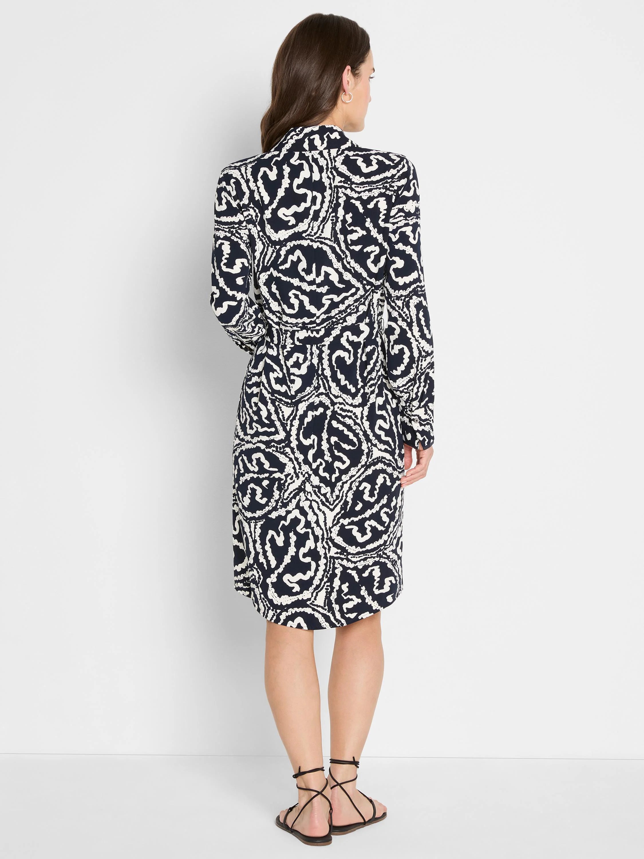 Indigo & off-white midi dress with an abstract swirly pattern, long sleeves, seen from the back.