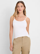 White ribbed knit cami with thin spaghetti straps, scoop neck, and close-fitting design.