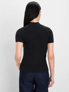 Black short-sleeve rib knit mockneck top on a model, shown from the back.
