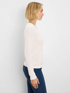 Off-white rib knit long-sleeve tee with side ruching, shown on a model in profile.