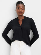 Black cable knit long-sleeve top featuring a split V-neck.