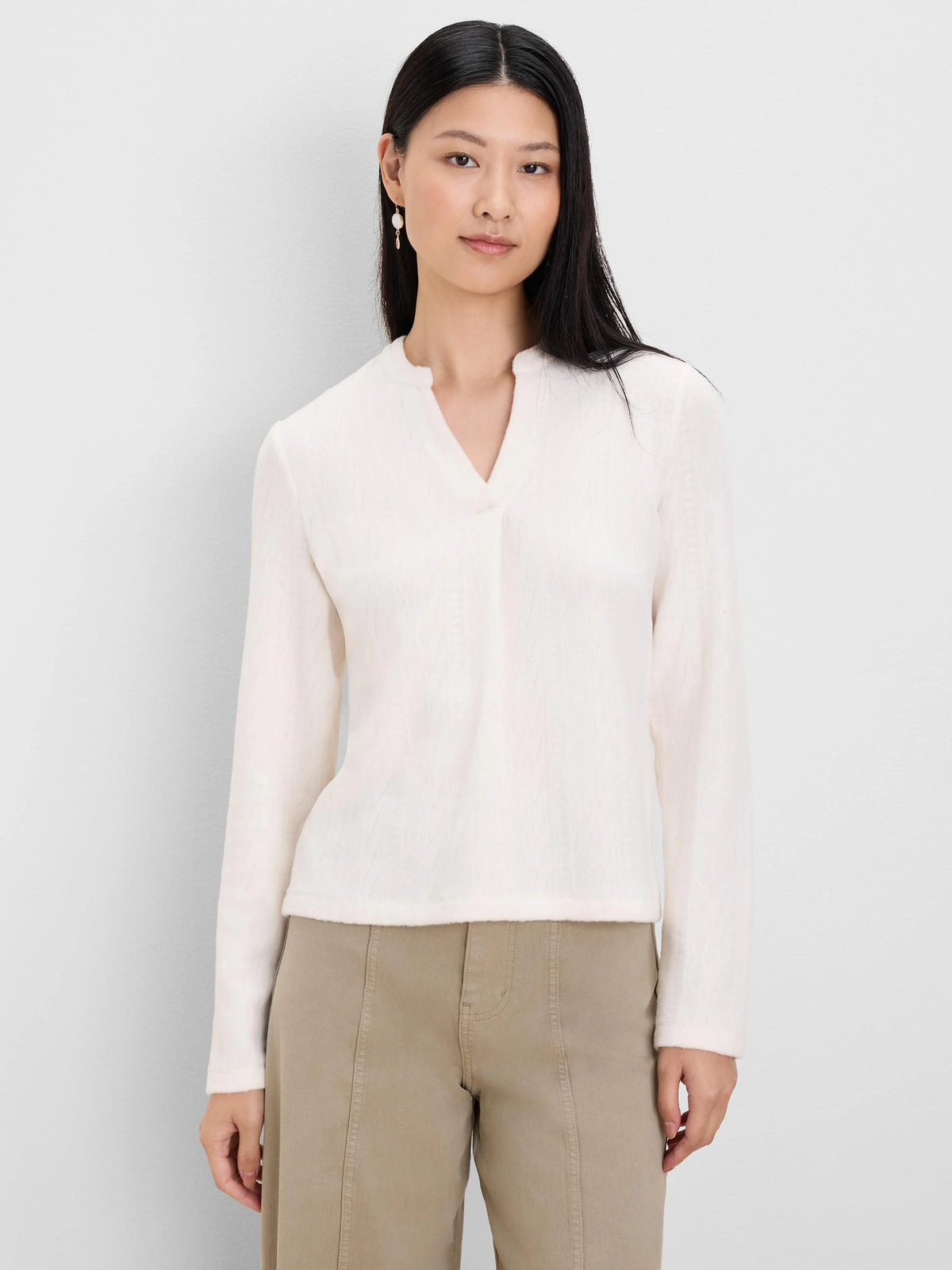 Cream long-sleeved top with a subtle cable texture and a split V-neck.