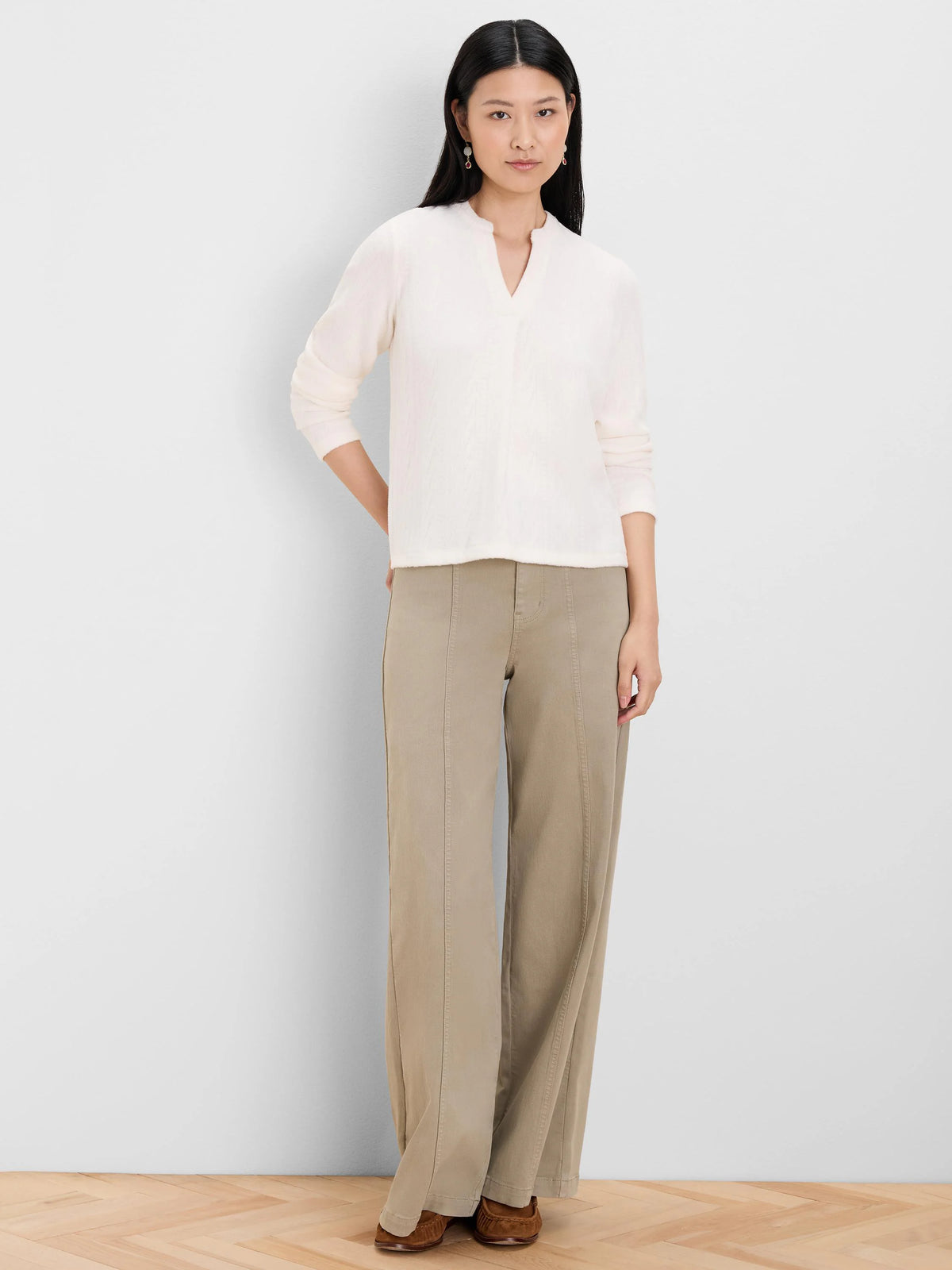 Cream split-neck top with subtle cable knit texture and long sleeves.