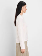Cream long-sleeve top with subtle cable knit pattern visible throughout the fabric.